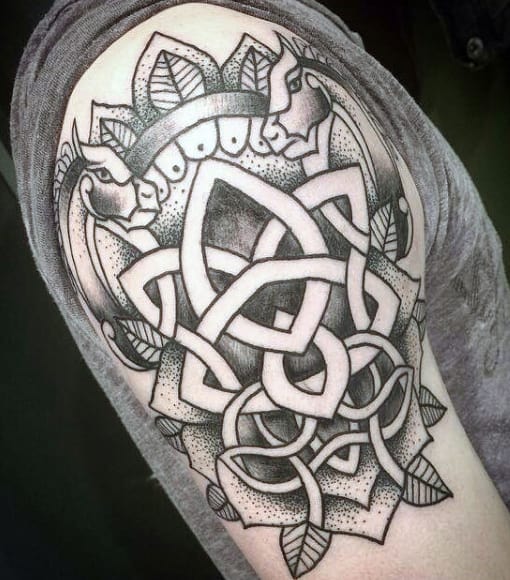 Ornate black and gray geometric tattoo on an upper arm with intricate patterns