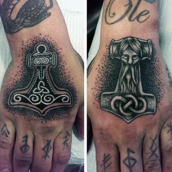 Close-up of hands with intricate Norse mythology inspired tattoos on the backs