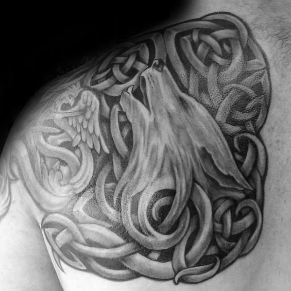 Howling Celtic wolf tattoo on shoulder with detailed shading, surrounded by dense knotwork and a hidden owl within the design.