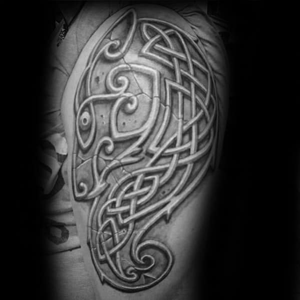 Celtic wolf head tattoo on upper arm with detailed knotwork and shaded curves forming an abstract, elongated wolf silhouette.