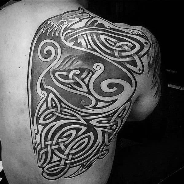 Celtic wolf tattoo covering shoulder and upper back with bold black lines, swirling knotwork, and a stylized wolf head outline.