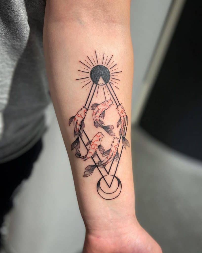 Geometric tattoo featuring koi fish swimming around interconnected sun and moon symbols, with fine linework and subtle red accents.