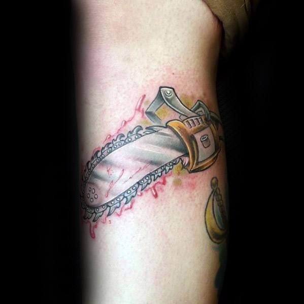 Colorful chainsaw tattoo with cartoon shading, cutting into the skin with pink blood splatter and metallic blade detail.