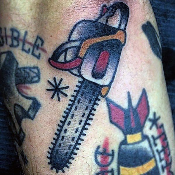 Traditional-style chainsaw tattoo with bold outlines, black blade, and red-orange accents, surrounded by old-school tattoo elements.