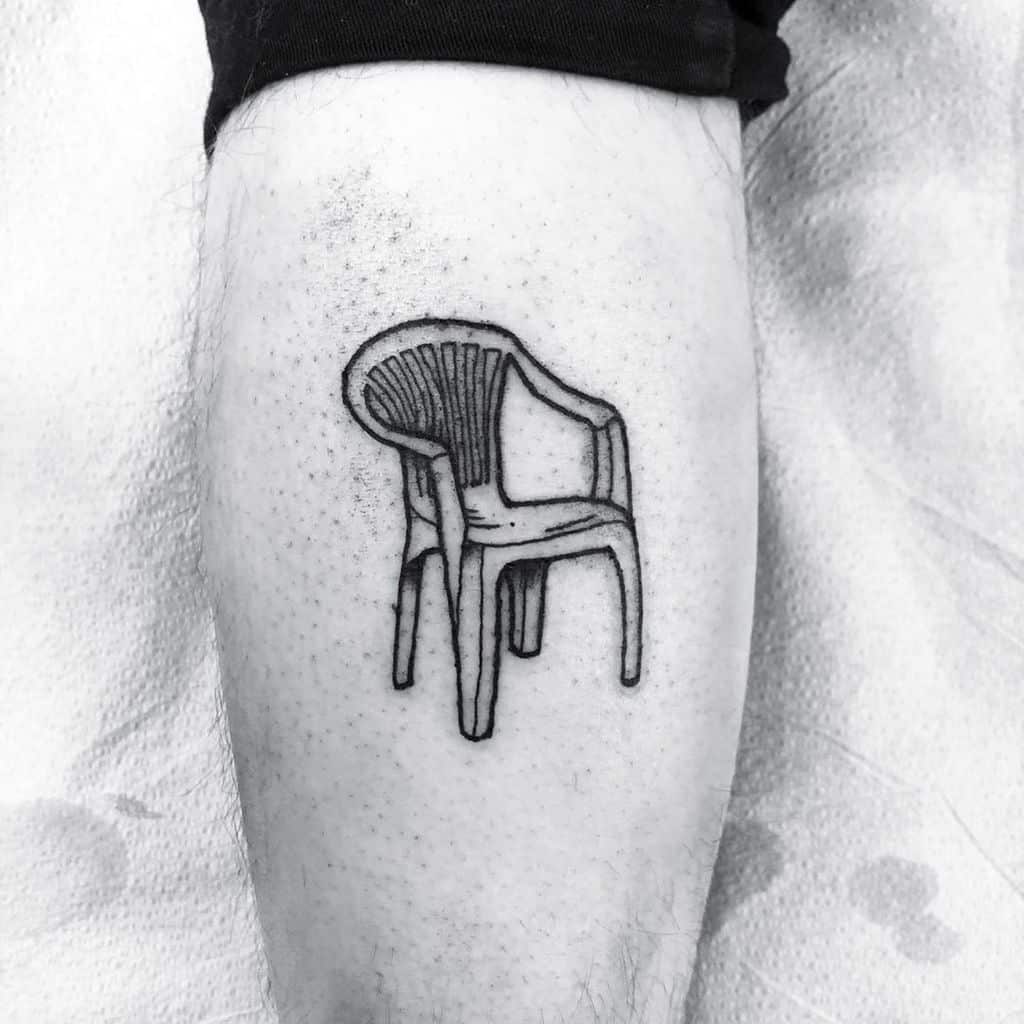 A black ink tattoo of a classic plastic chair, drawn with a sketch-like style, creating a humorous and nostalgic design.