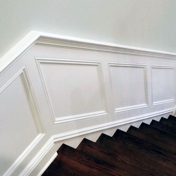 Elegant staircase wall with white chair rail molding and dark wood steps for a classic, sophisticated design