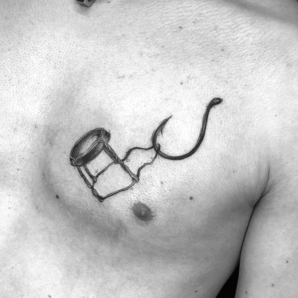 Realistic tattoo of a champagne wire cage attached to a fishing hook, placed on the chest with detailed shading.