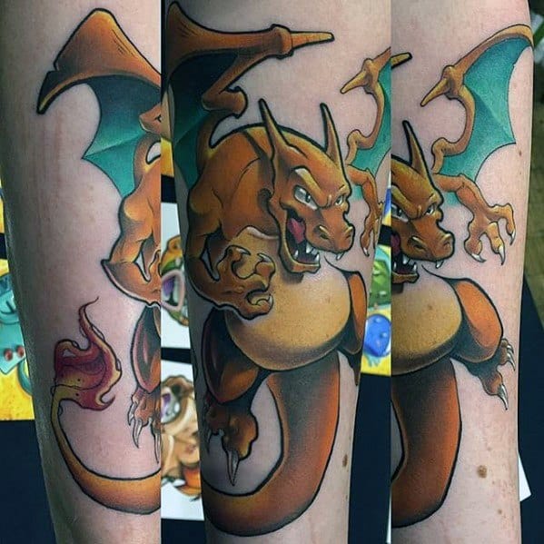 Dynamic Charizard tattoo wrapping around the forearm, showing fierce eyes, sharp claws, and a flaming tail in vivid detail.