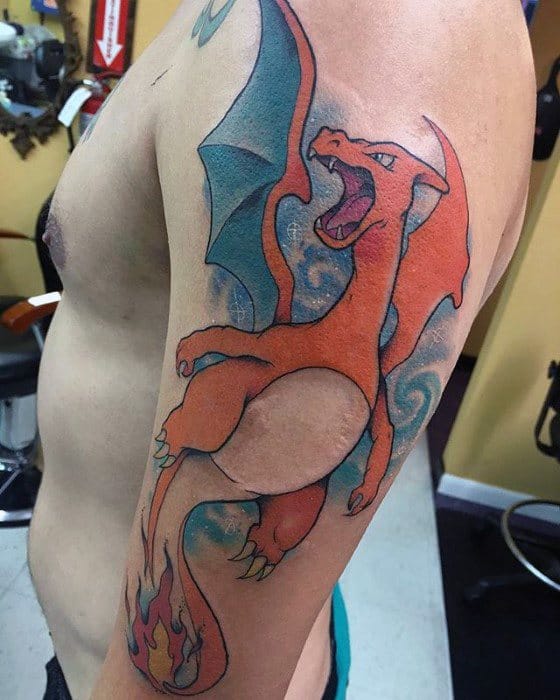 Large Charizard tattoo with wide wings and blazing tail, soaring upward with a fierce roar and swirling blue smoke backdrop.