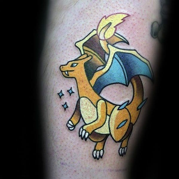 Clean and vibrant tattoo of shiny Charizard in golden tones, with sparkles and teal wings for a bold, standout look.