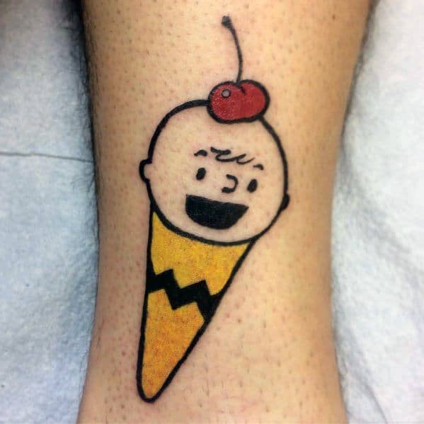Fun and quirky Charlie Brown ice cream cone tattoo, featuring his signature yellow shirt pattern and a cherry on top for a playful twist.