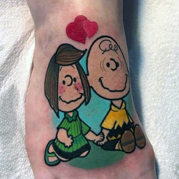Colorful Charlie Brown and Peppermint Patty tattoo, holding hands with hearts above, capturing a sweet and nostalgic Peanuts love moment.