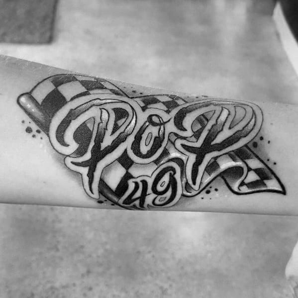 Checkered flag tattoo with bold script reading "POP 49," blending racing symbolism with a personal tribute in dynamic lettering.