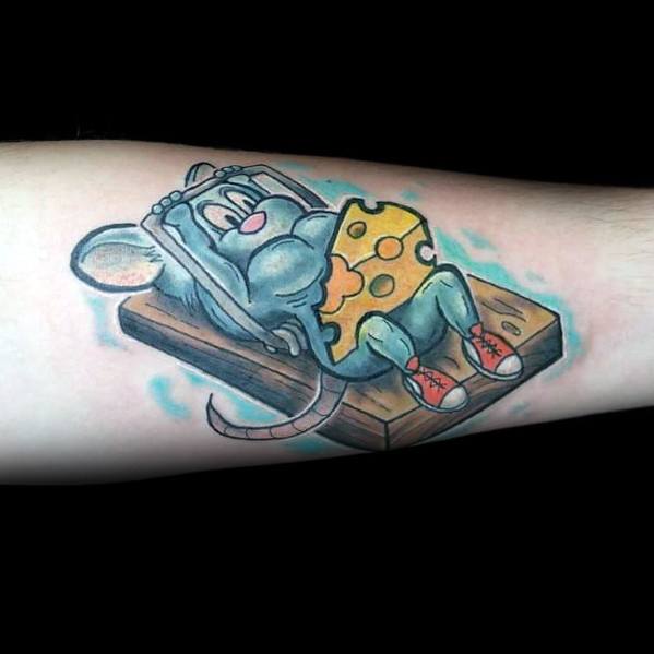 Colorful tattoo of a cartoon mouse relaxing on a mousetrap, using a wedge of cheese as a blanket, featuring vibrant shading and playful details.