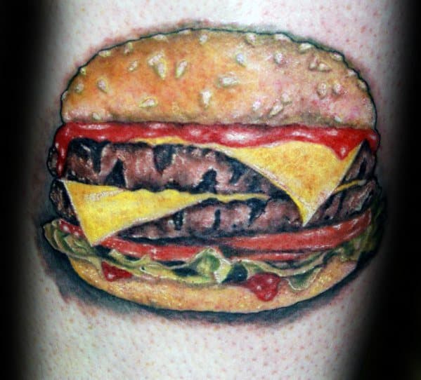 Cheeseburger tattoo with lettuce, tomato, cheese, and ketchup on a bun