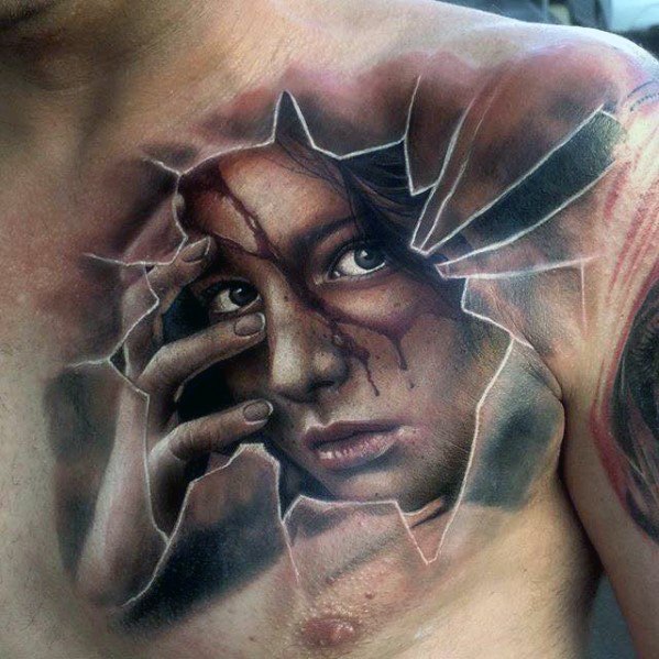 Tattoo of a woman's face peering through a cracked surface on a man's chest