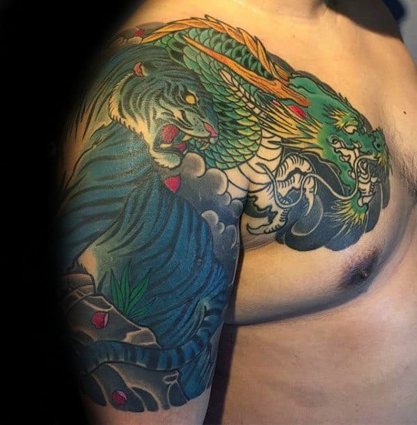 A detailed dragon and tiger tattoo covering the shoulder and upper arm