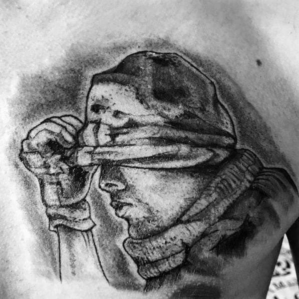 Realistic Call of Duty Ghost tattoo in black and grey, featuring a soldier pulling down his mask with detailed shading and a rugged look.