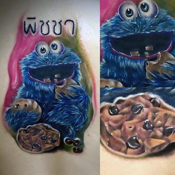 Colorful Cookie Monster tattoo with Thai script, holding cookies with big eyes and vibrant pink-green background swirls.