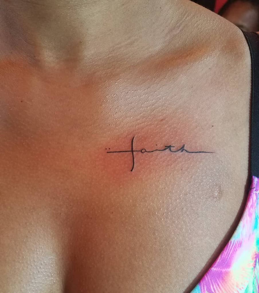 A delicate tattoo of the word "faith" adorns the skin near the collarbone, a subtle reminder of inner strength and belief, with a small cross seamlessly integrated into the design to symbolize unwavering devotion and hope