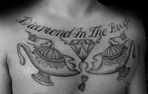 Chest tattoo featuring "Diamond in the Rough" with two ornate genie lamps and a diamond design