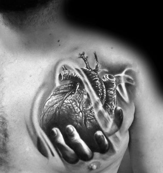 Black and grey 3D tattoo of a realistic anatomical heart held by a hand, with smooth shading and depth creating a dramatic chest design.