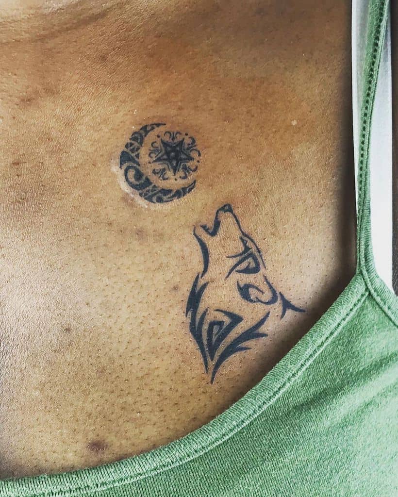 Tattoo of a howling wolf and a patterned crescent moon on a chest