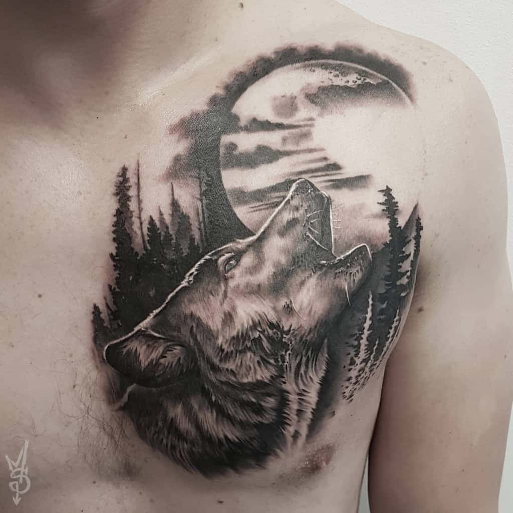 A striking chest tattoo features a majestic wolf howling at the moon, encircled by silhouettes of trees and swirling clouds