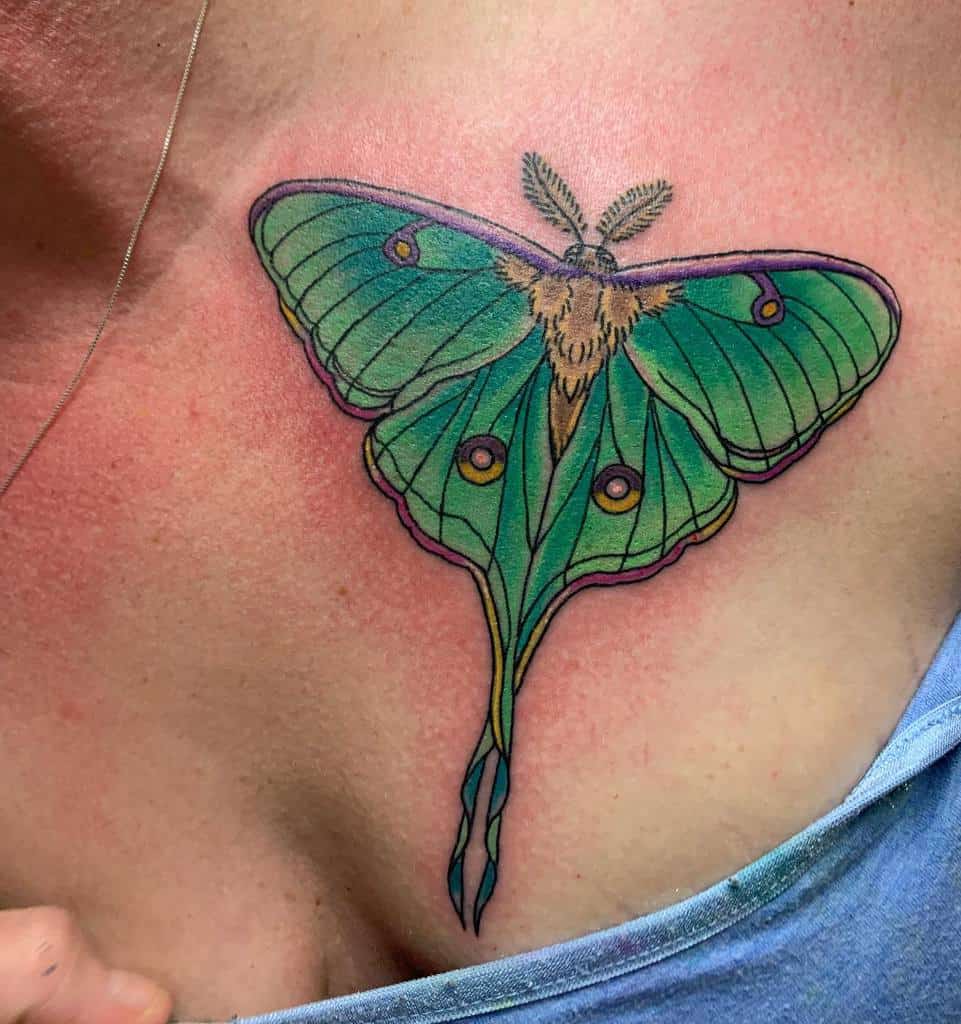 A colorful Luna Moth tattoo, featuring green and purple hues with detailed wing patterns