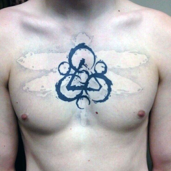 Coheed and Cambria Keywork chest tattoo with faded wings in the background, blending symbolic power with soft, abstract detail.