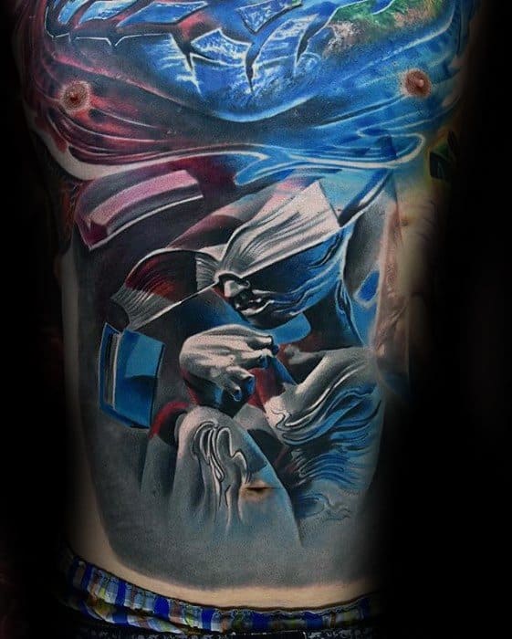 Surreal full torso tattoo featuring abstract floating figures, a dreamy underwater scene, and vivid blue and red cosmic elements.