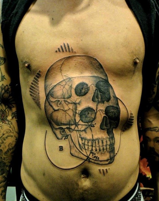A person with a detailed anatomical skull tattoo on their torso