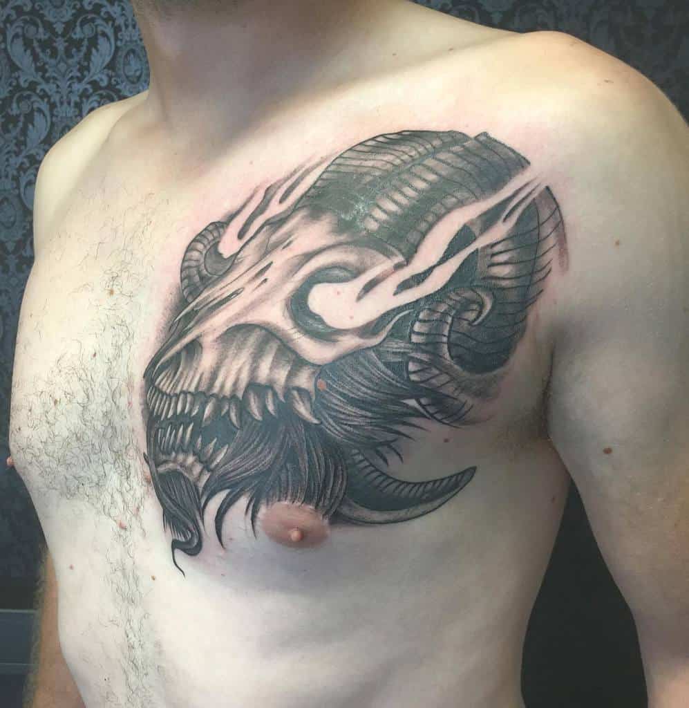 A man with an intricate tattoo of a ram skull with prominent horns on his chest