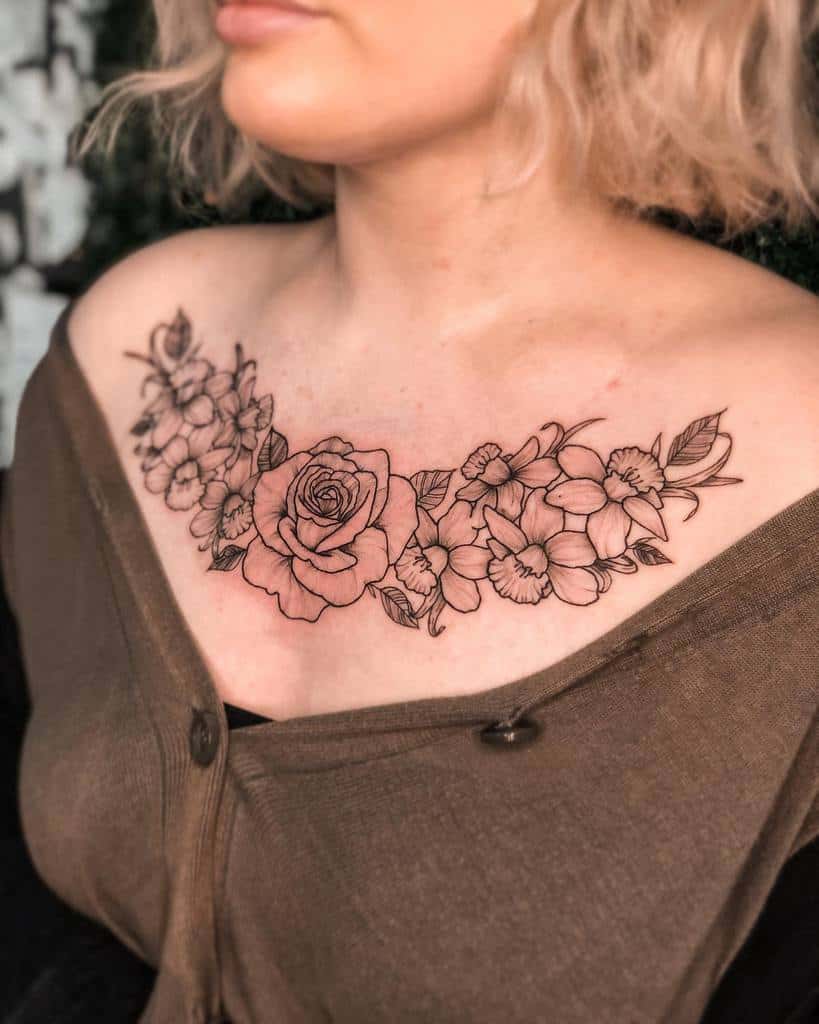 Delicate floral chest tattoo with a central rose surrounded by intricate blossoms and leafy details, emphasizing elegance and symmetry