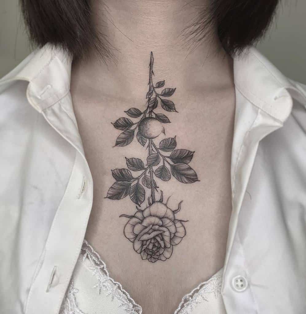 Chest tattoo of a rose with leaves and a delicate stem