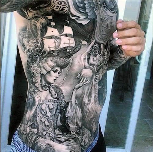 A detailed full-torso tattoo depicting a ship, a woman, and various intricate designs