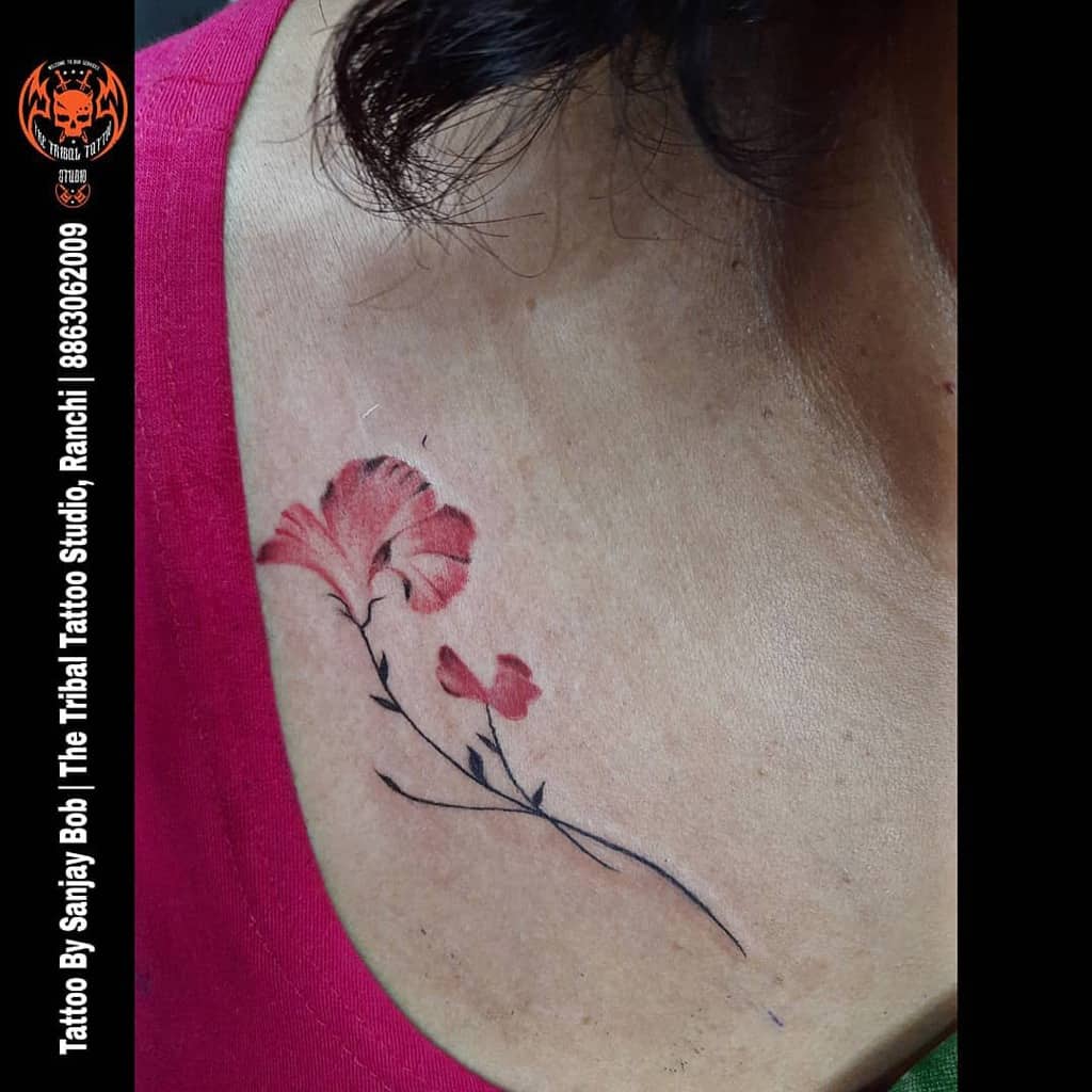 Collarbone tattoo of a pink flower with a stem and leaves