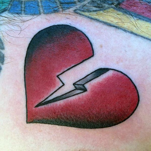 A bold, red and black broken heart tattoo with a jagged crack down the middle