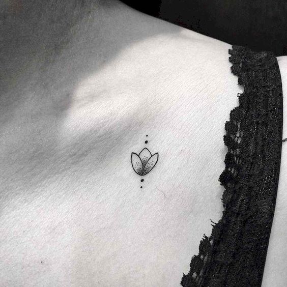 A small minimalist tulip tattoo on the collarbone, featuring a simple black-line flower with dot accents for an elegant and subtle design.