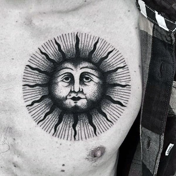 Black sun face tattoo on chest with rays extending outwards