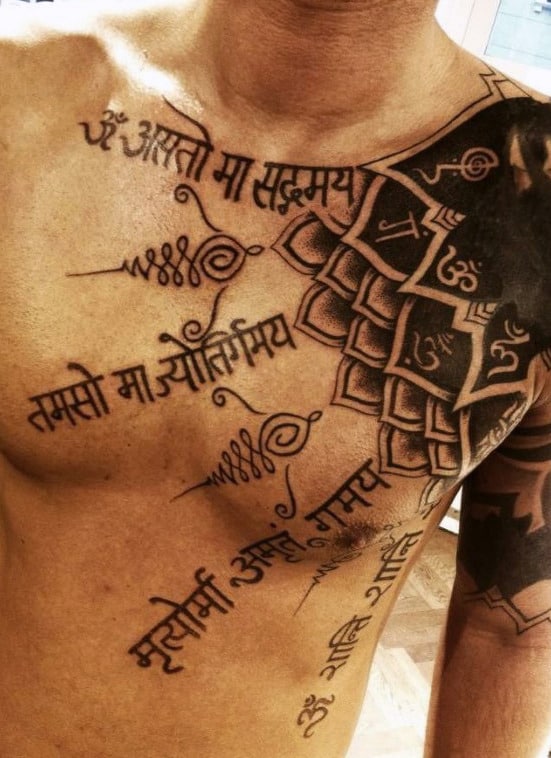 Chest and shoulder tattoo with Sanskrit script and geometric patterns