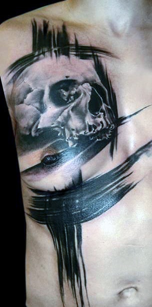 Tattoo of a skull on a person's side with bold black brush-like strokes