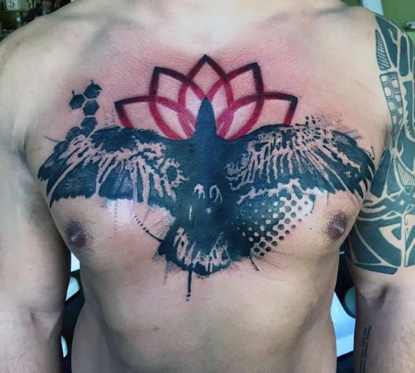 Chest tattoo of a black bird with open wings and a red geometric pattern above
