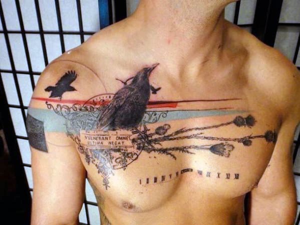 Man's chest tattoo featuring crows, a ribbon, and decorative elements
