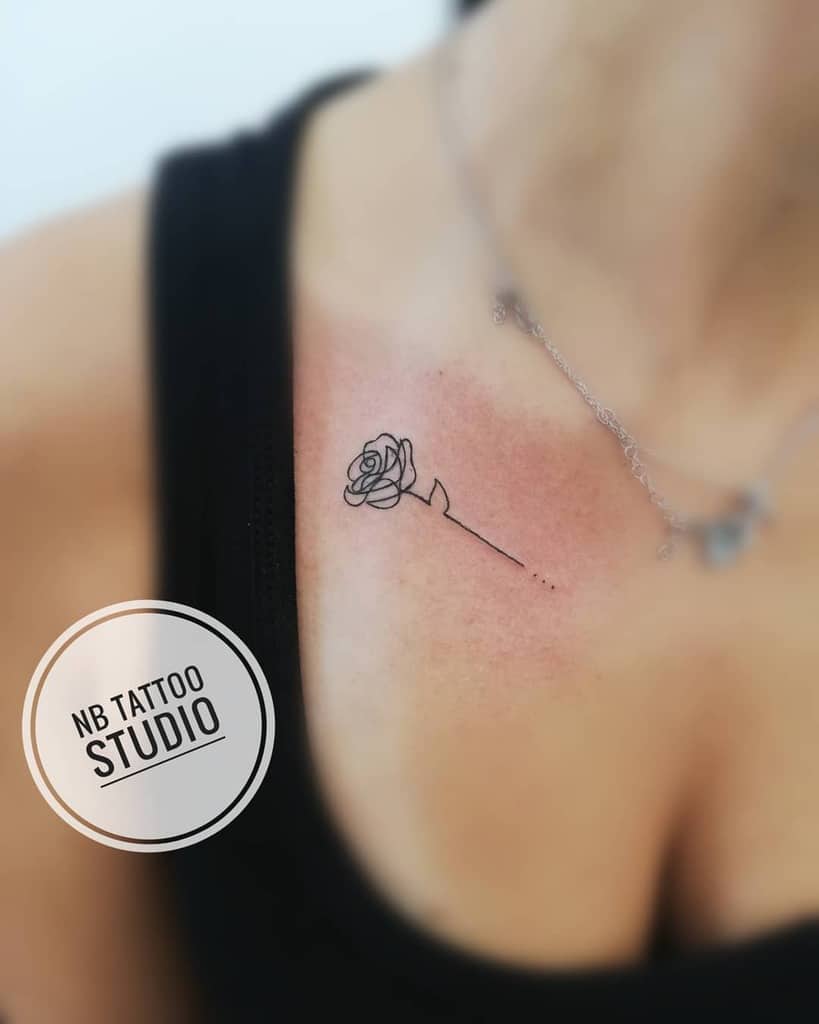 Minimalist rose tattoo on a woman's collarbone