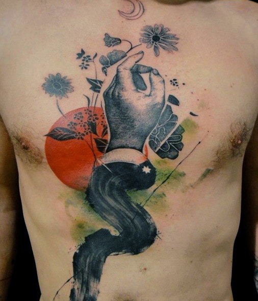 Chest tattoo of a hand surrounded by flowers, a red circle, and abstract elements