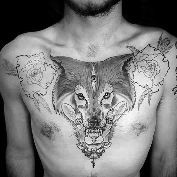 Large chest tattoo featuring a wolf head with a third eye, a sheep’s head underneath, and roses on both sides.