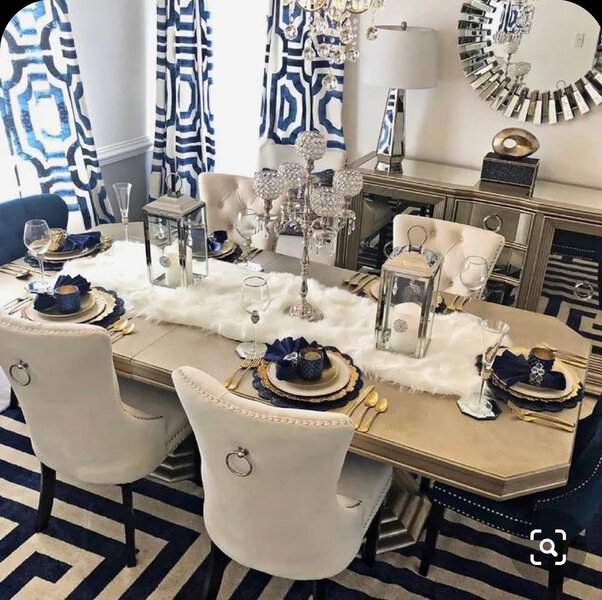 Glamorous dining room with bold geometric curtains, a mirrored sideboard, and an elegant table setting.