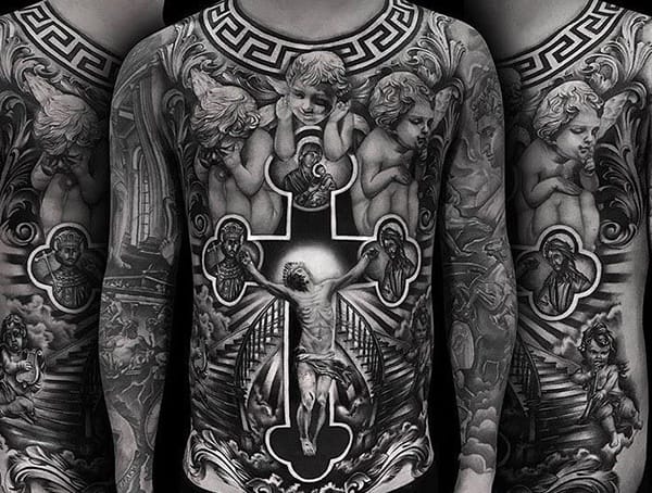 Black and grey religious tattoo covering the full torso and arms, featuring angels, a crucifix, and intricate details in a realistic style.