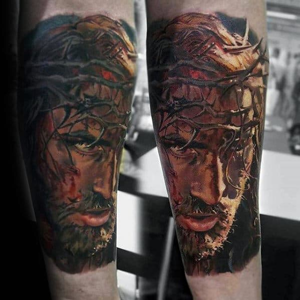 Forearm tattoo depicting a detailed portrait of Jesus wearing a crown of thorns